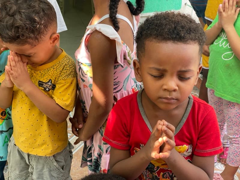 Children praying together at Una Luz Foundation in Cartagena, Colombia