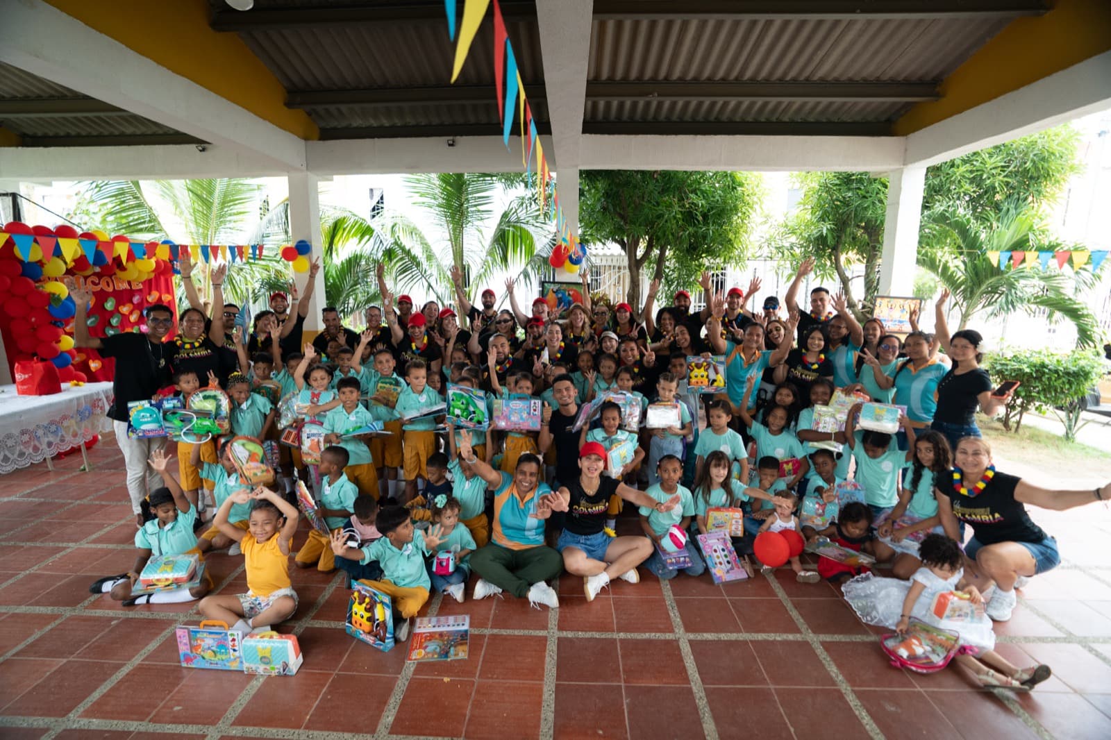 A corporate team and children celebrating together at Una Luz Foundation in Cartagena, Colombia